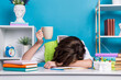 © deagreez - Portrait of exhausted girl fell asleep office desk hand hold tea mug isolated on blue color background