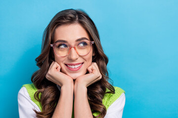 Poster - Photo of creative minded lady arms touch cheekbones look empty space isolated on blue color background