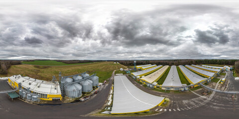 Canvas Print - aerial seamless 360 hdri panorama view among rows of agro farms with silos and agro-industrial livestock complex in equirectangular spherical projection with overcast sky with gray rain clouds