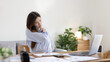 © Puwasit Inyavileart - Asian woman sore muscles and neck after sitting at work or homework for a long time, Suffering from muscle aches and tendon pressure, Massage your shoulders to relax your muscles, Work from home.