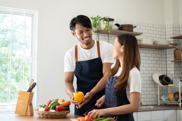 Wall Mural - Couple cooking together. Happy young couple cooking together in the kitchen. valentine day concept.