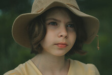 Portrait Of A Blue-eyed Girl 10 -13 Years Old In A Hat And A Yellow Dress In Nature
