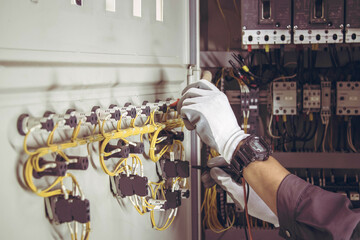 Wall Mural - Electrician engineer tests electrical installations and wires on relay protection system.