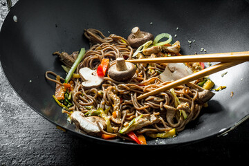 Poster - Hot soba noodles in a wok pan with mushrooms, sauce and beef.