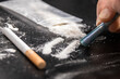 Drug Addiction: Close-up of person using a 20 euro note to snort cocaine on a black table
