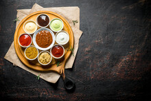 Big Set Of Sauces On A Cutting Board With Paper.