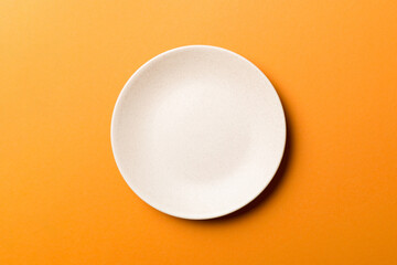 Top view of isolated of colored background empty round beige plate for food. Empty dish with space for your design