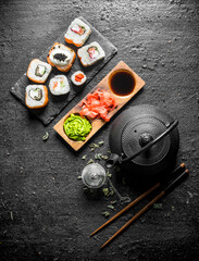 Canvas Print - Pieces of delicious Japanese sushi rolls with green tea and sauces.