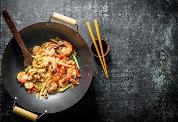 Canvas Print - Freshly cooked Asian Udon noodles in a wok pan with soy sauce and chopsticks.