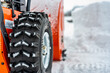 Selective focus on snowblower tires with a defocused drift of snow in background..