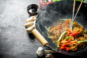 Wall Mural - Freshly cooked Chinese noodles wok funchoza with salmon, vegetables and sauce.