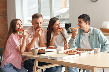 Wall Mural - Group of friends eating tasty pizza at table in kitchen