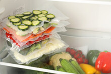 Vacuum Bags With Different Vegetables In Fridge, Space For Text. Food Storage