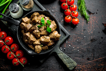 Poster - Fried liver with spices and cherry tomatoes on a cutting Board.