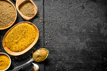 Poster - Different types of mustard on a stone Board with garlic.