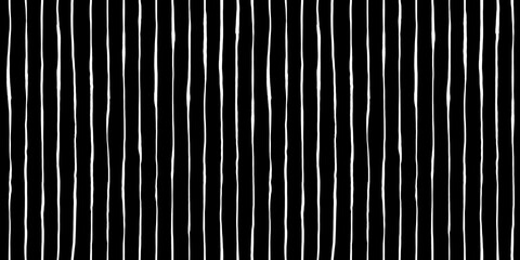 Seamless hand drawn vertical pinstripe pattern made of fine wonky white stripes on black background. Abstract simple classic blender motif with linocut print texture in a trendy doodle line art style.