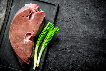 Poster - Raw liver on a cutting Board with green onions.