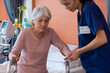 © wavebreak3 - Diverse female doctor helping senior female patient use walking frame, copy space