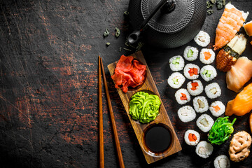 Sticker - Different types of Japanese sushi, rolls and maki with sauce, wasabi and green tea in a teapot.