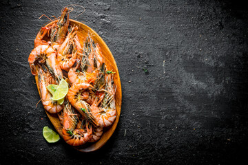 Sticker - Boiled shrimps on a wooden plate with chopped lime.