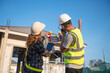 © somchai20162516 - Construction inspector and female architect discuss with chief engineer Asia about installing solar panels on a construction project. Visit the construction site to install solar panels.