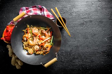 Wall Mural - Finished Udon noodles in a wok pan with soy sauce, chopsticks and a napkin.