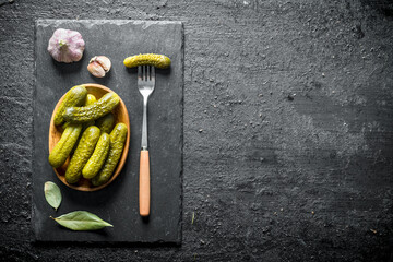 Poster - Preserved cucumbers the plate on a stone Board with the Bay leaf and garlic.