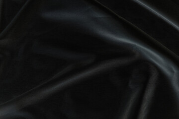 Smooth elegant black silk fabric or satin luxury cloth texture for abstract background