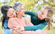 © J Maas/peopleimages.com - Retirement hug, seniors and bonding women in nature park, grass garden or relax environment in trust, community or security. Smile, happy and elderly friends in embrace for support or birthday pride