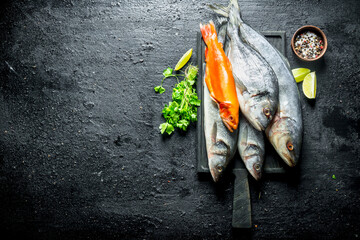 Canvas Print - Fresh sea fish with lime slices, parsley and spices.