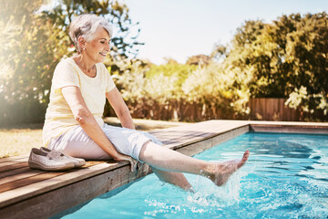 Poster - Relax, travel and senior woman by the pool while on a vacation, adventure or outdoor trip in summer. Happy, smile and elderly lady in retirement with her feet in the swimming pool at a holiday resort