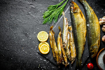 Canvas Print - Smoked fish with dill, lemon slices and garlic cloves.