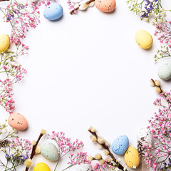Wall Mural - Overhead shot of Easter composition with spring flowers and colorful quail eggs over white background. Springtime and Easter holiday concept with copy space. Top view
