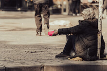 A Beggar Sits On The Street