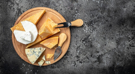 Wall Mural - Parmesan. Different types of cheese with knife on a dark background. Cheeses set dor blu chedar camamber brie. place for text, top view