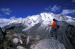 © Cavan Images - Man standing on a peak looking out at snow covered mountains in Cordillera Blanca, Peru.