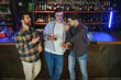 © Serhii - male friends spending time together in bar and having fun. Bearded men smiling, looking at each other and communicating. Men holding crystal glasses of whisky or scotch.