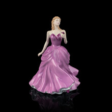 Vintage Porcelain Figurine Of A Woman In A Long  Pink Dress On A Black Background.