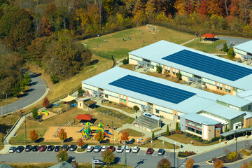 Wall Mural - Roof of american school building covered with photovoltaic solar panels for production of electric energy. Renewable energy concept