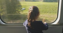 Cinematic And Symmetrical Beautiful Shot Of A Little Girl Traveling By Train With Her Parents, Child Looks Out The Window Of The Tourist Train At The Landscape. Travel Inspiration Passion For Travel 