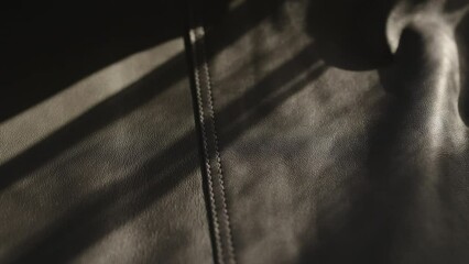 Wall Mural - Slow motion handheld shot of soft gray leather jacket with bright sun light