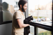 Content Man With Black Cat Near Window