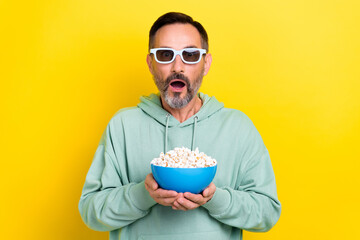 Poster - Photo of retired excited man brunet hair open mouth speechless hold popcorn stunned incredible moment film isolated on yellow color background