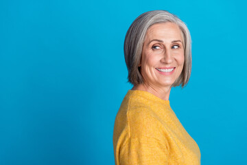 Sticker - Photo portrait of mature lovely lady turn around curious look empty space dressed stylish yellow outfit isolated on blue color background