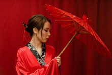 A Girl In A Red Kimono With A Red Umbrella On A Red Background