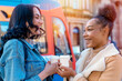 © Iryna - two women in a denim jacket is talking to each other , drinking coffee  and waiting for a tram at the stop Lifestyle photo