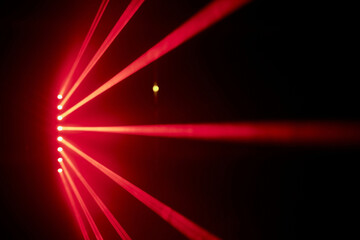 Bright red neon laser lights illuminate the darkness creating lines and triangle shapes in sci-fi effect.