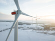 Wind turbine in a snowy winter landscape seen from an aerial view