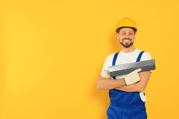 Sticker - Professional worker with putty knife in hard hat on orange background, space for text