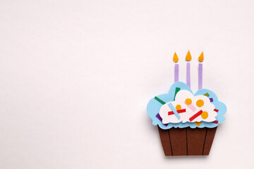 Wall Mural - Birthday party. Paper cupcake with candles on white background, top view and space for text